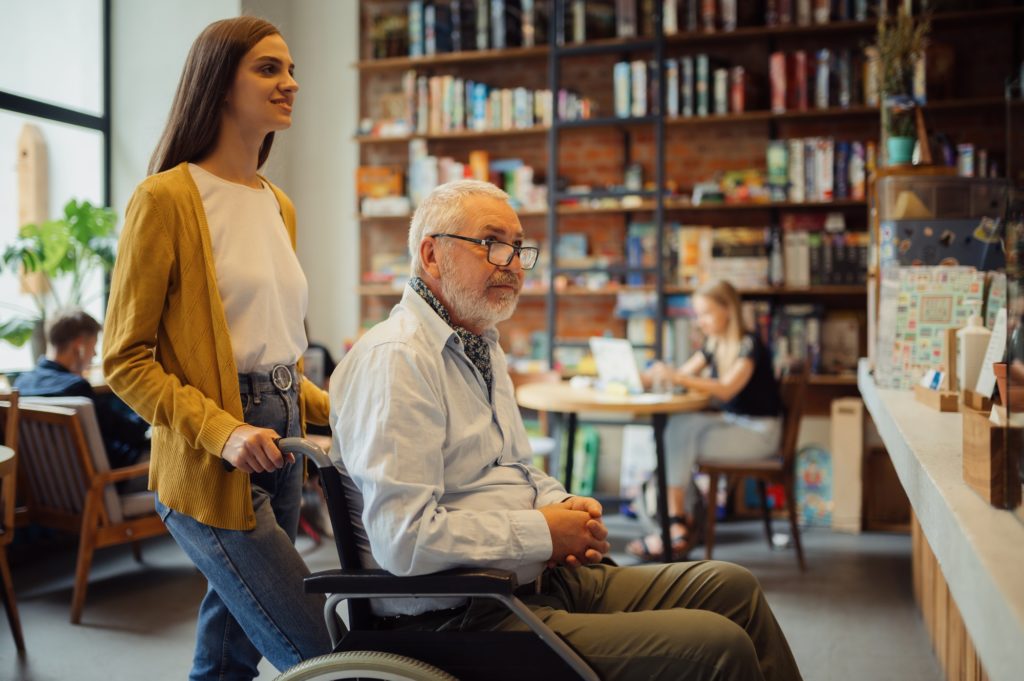 Handicapped older male person and young guardian