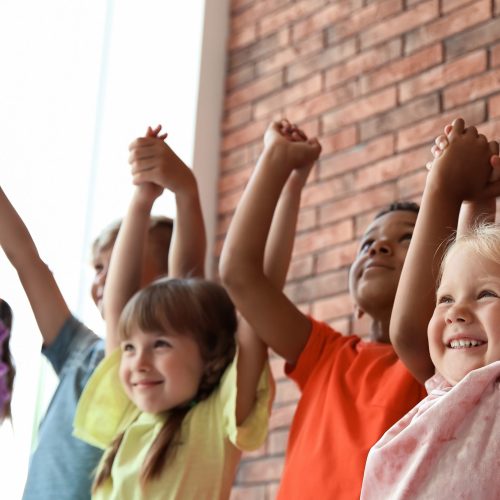 Little children holding hands together indoors. Unity concept
