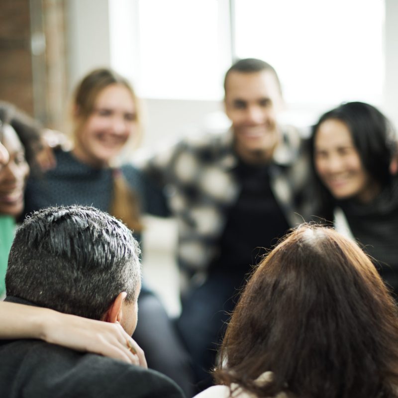 Happy people huddling in a room