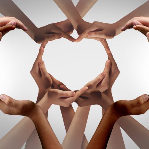Unity and Togetherness or diversity partnership as heart hands in a group of diverse people connected together shaped as a support symbol expressing the feeling of teamwork.