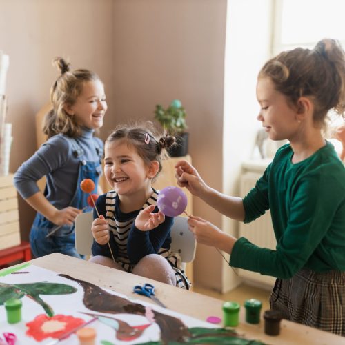 A group of little kids working on project during creative art and craft class at school.