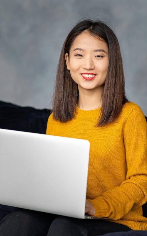 asian-business-woman-working-in-laptop-on-sofa-jap-4PNLNCB.jpg