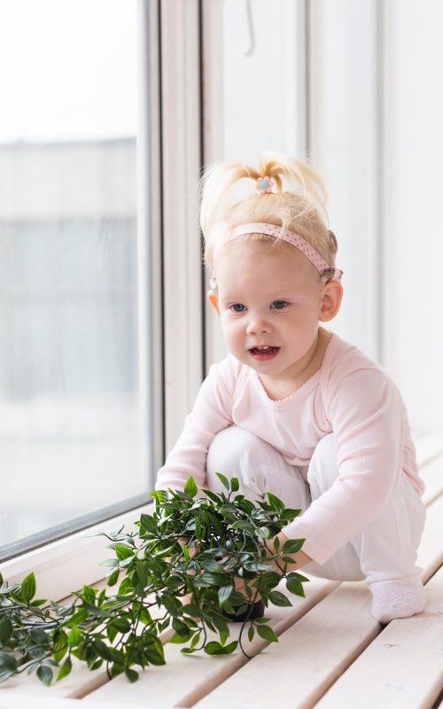 Baby with cochlear implants at home. Deafness and medical technology concept.