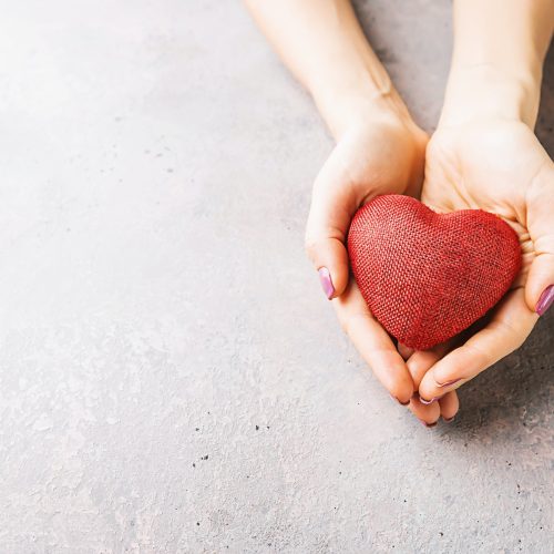 Female hands giving red heart