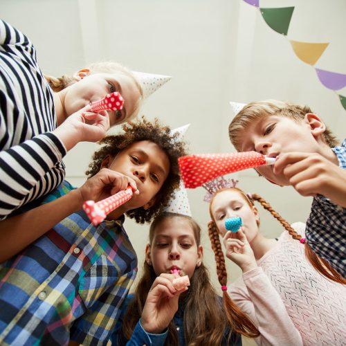 Group of Children Blowing Party Horns Group of Children Blowing Party Horns