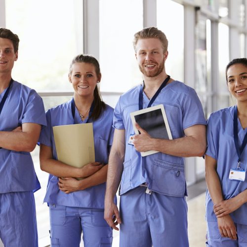 Group portrait of healthcare workers in hospital corridor