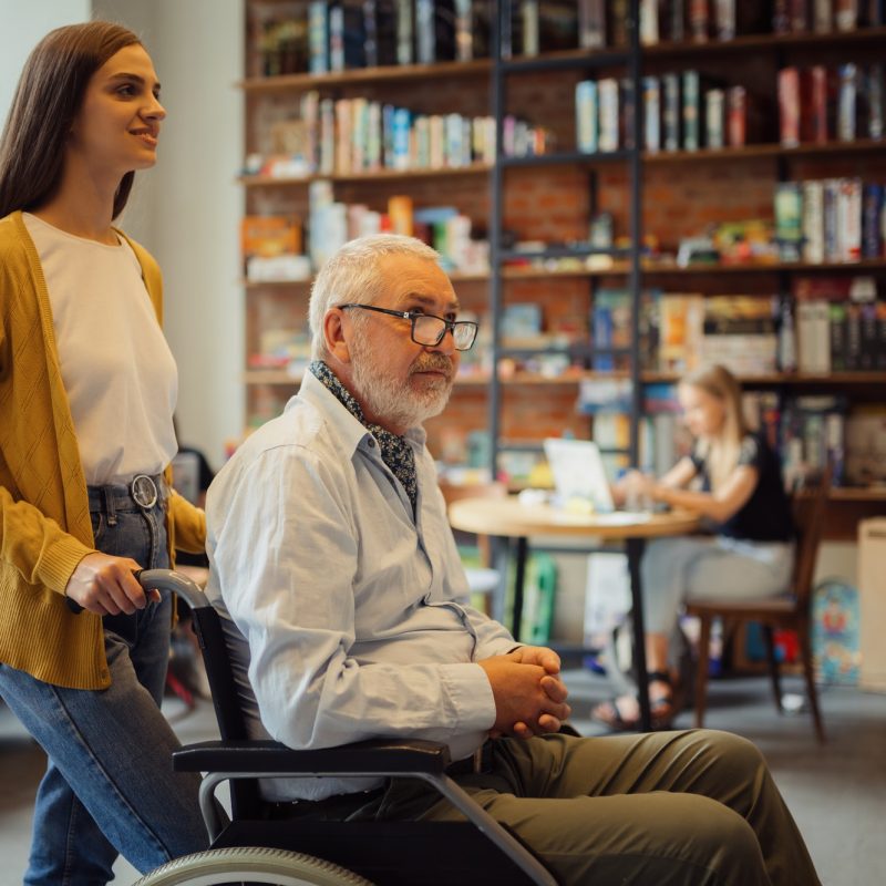 Handicapped older male person and young guardian
