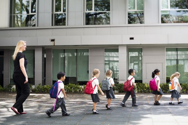 Kindergarten students walking crossing school road