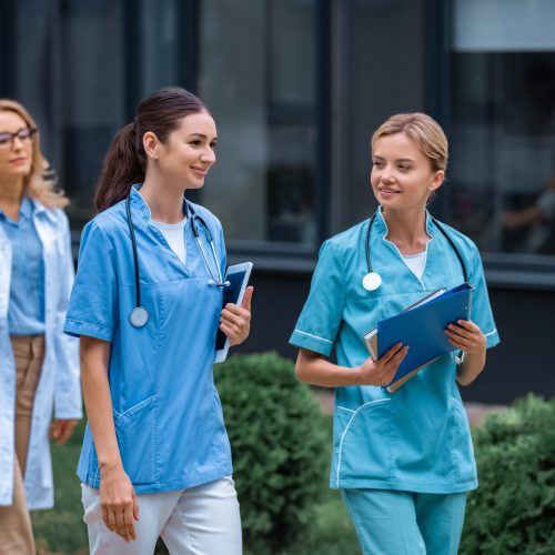medical students and lecturer walking on street near university