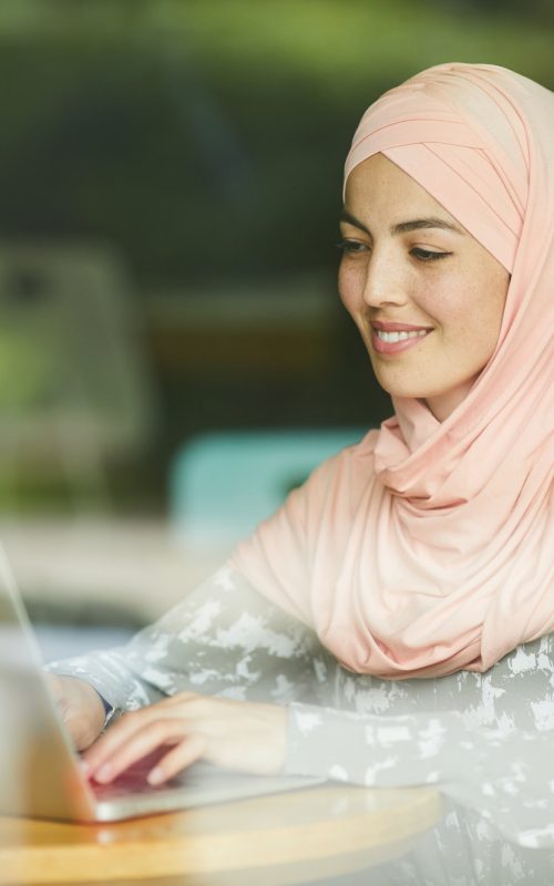 Muslim woman answering e-mails Muslim woman answering e-mails