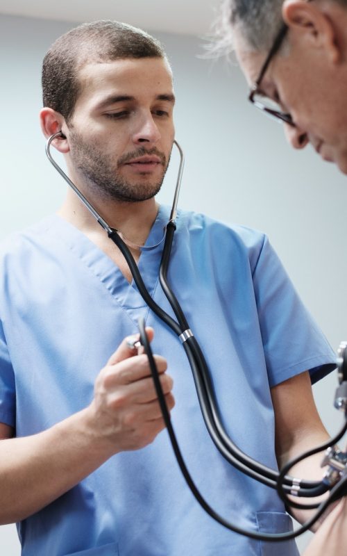 Nurse and Doctor Measure Hispanic Old Man Blood Pressure