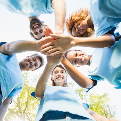 Portrait of volunteer group forming huddles