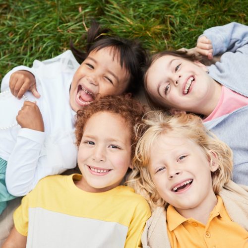 Smiling Children Lying on Grass Smiling Children Lying on Grass