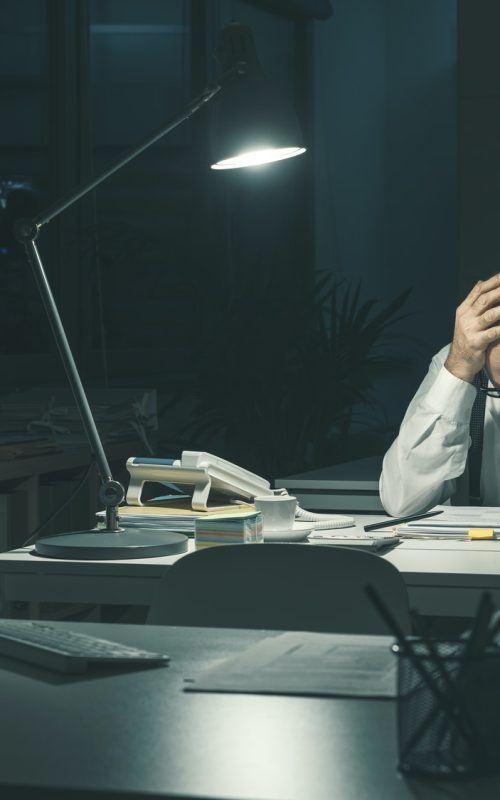 Stressed business executive working overtime Stressed business executive working overtime