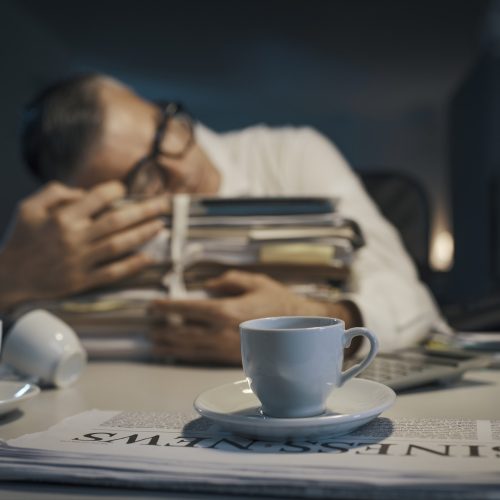 Stressed office worker sleeping at his desk Stressed office worker sleeping at his desk