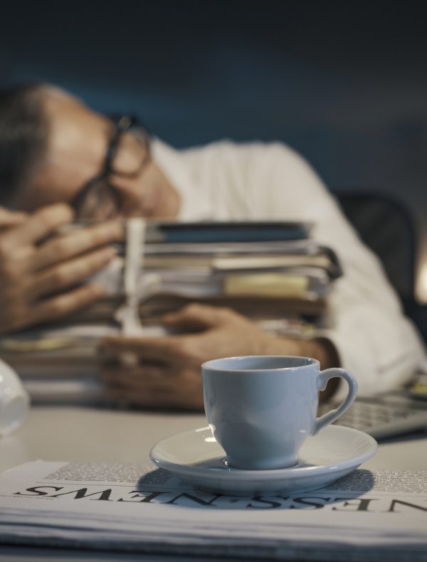 Stressed office worker sleeping at his desk