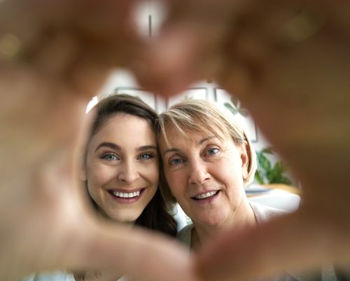 Two women shaping hands to a heart