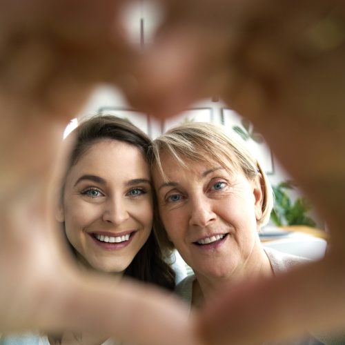 Two women shaping hands to a heart